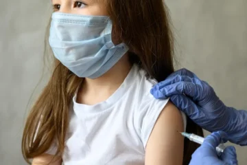 Dziewczynka otrzymuje szczepionkę przeciw COVID-19