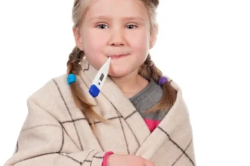 Chore dziecko z termometrem na białej przestrzeni