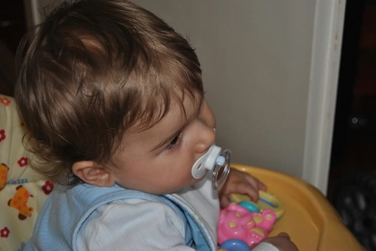 Chłopiec ssający smoczek w domu