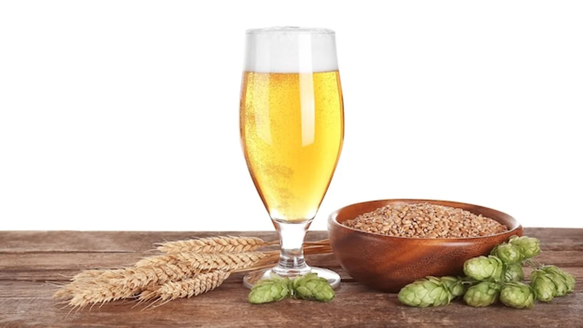 Szklanka jasnego piwa i składników na drewnianym stole