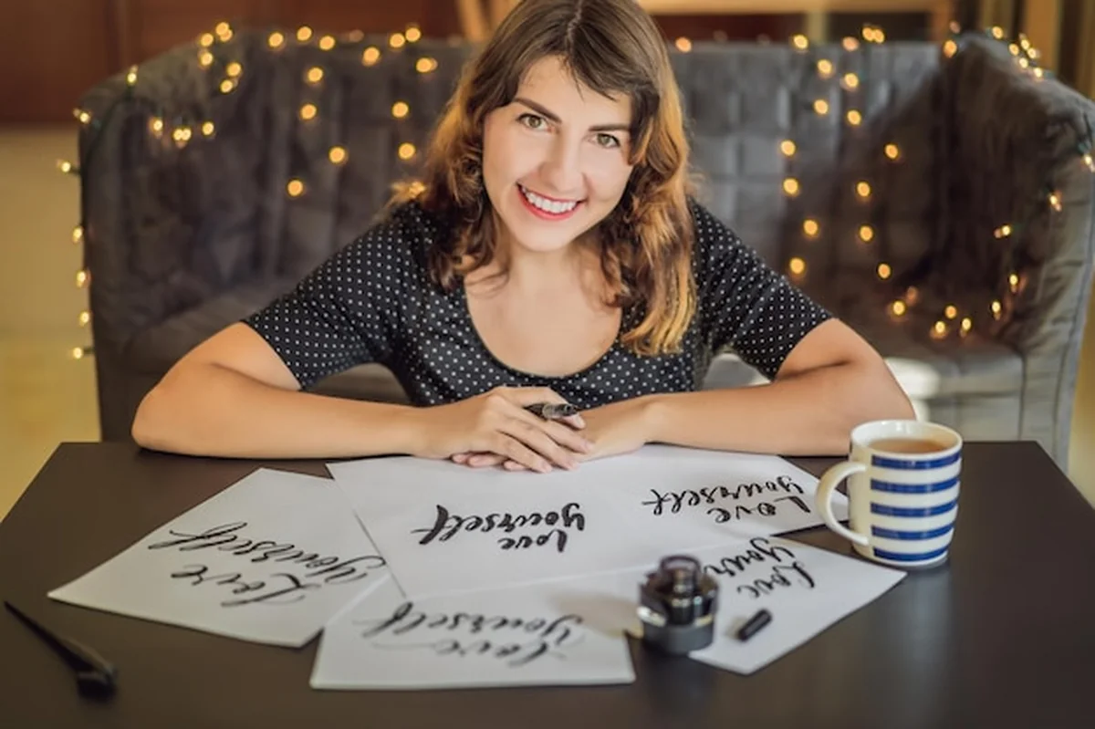 Młoda kobieta pisząca kaligrafię na białym papierze