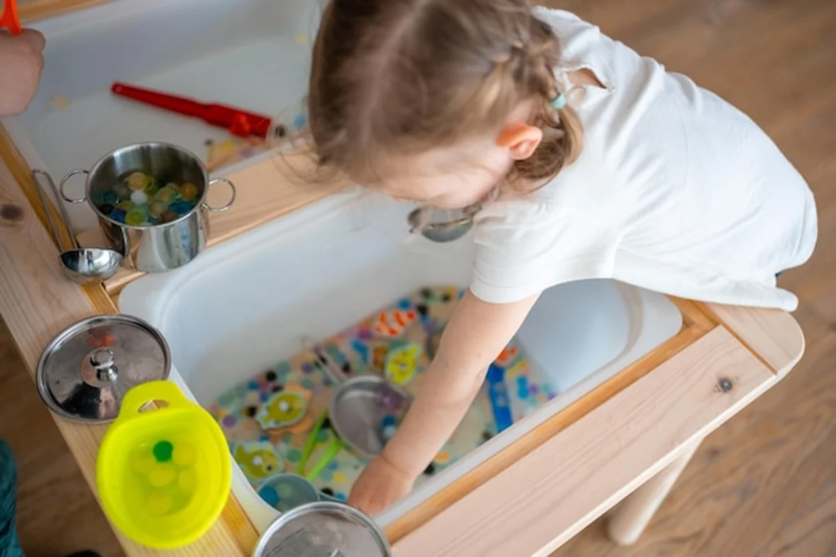 Dziewczynka bawi się koralikami wodnymi