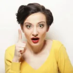 Młoda kobieta z uniesionym palcem