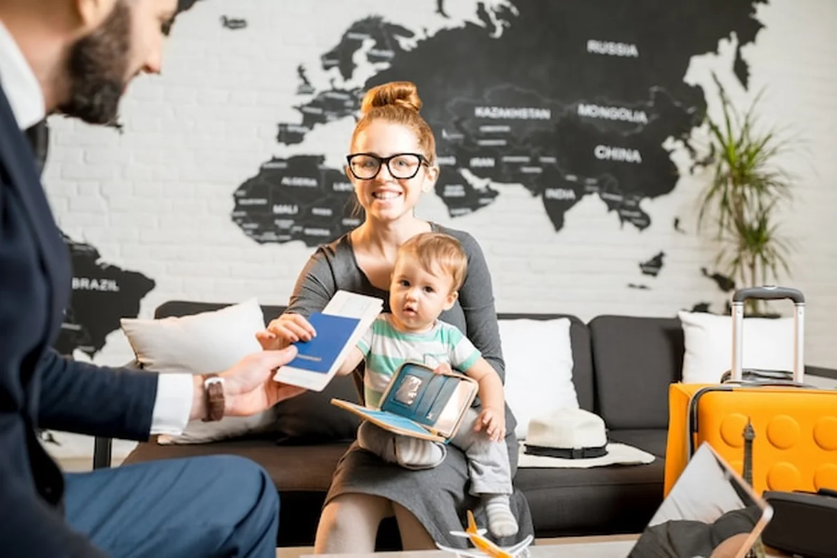 Rodzina i agent w biurze podróży z mapą, biletami i paszportem na letnie wakacje