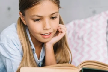 Urocza mała dziewczynka czyta książkę