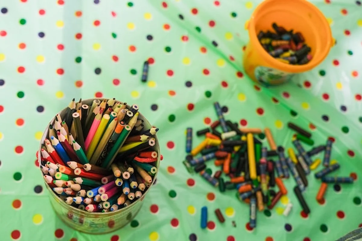 Kolorowe ołówki w dużym słoiku na stole