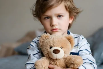 Smutny chłopiec z pluszowym
